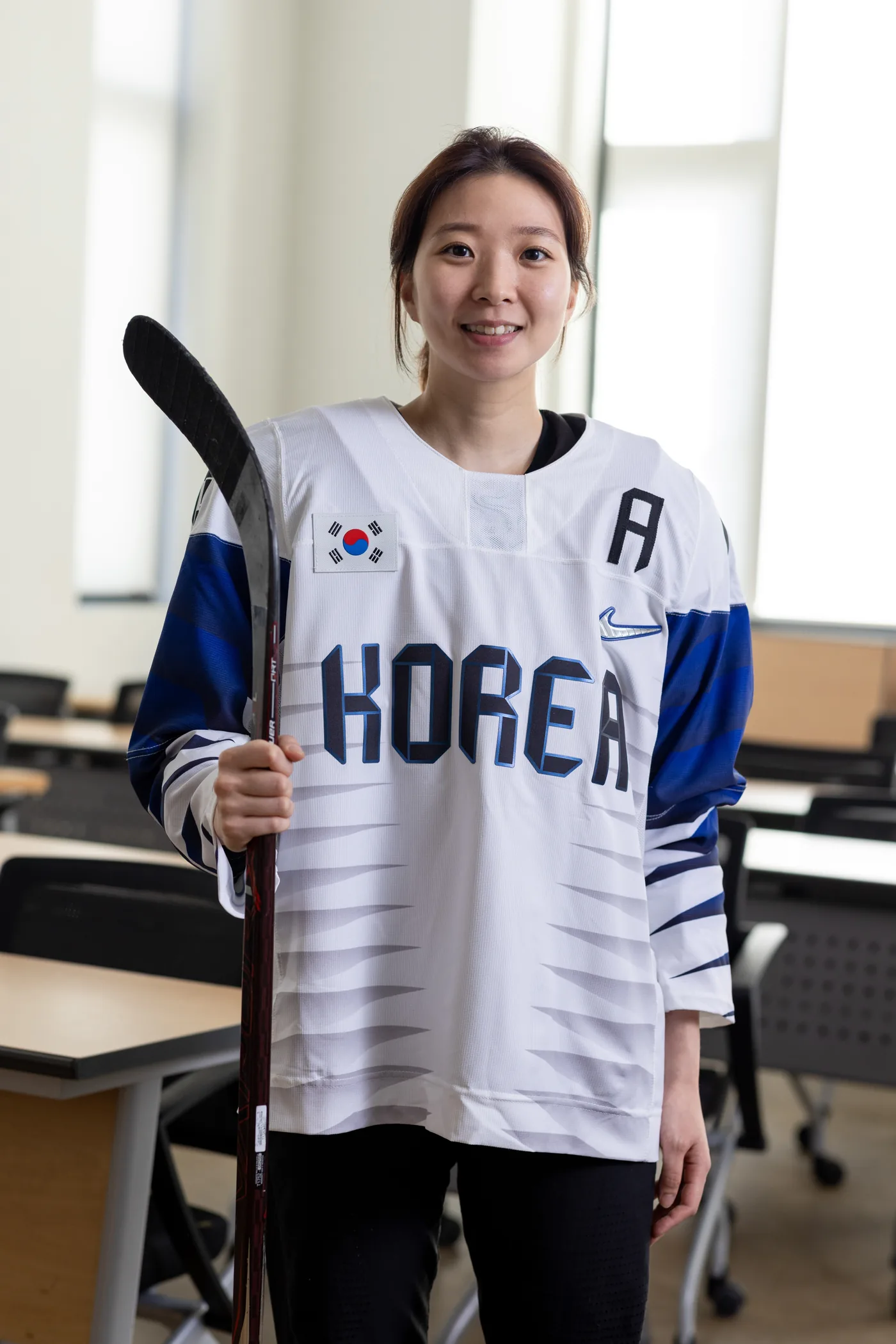 Susie Jo in the Korea national team jersey, holding a hockey stick